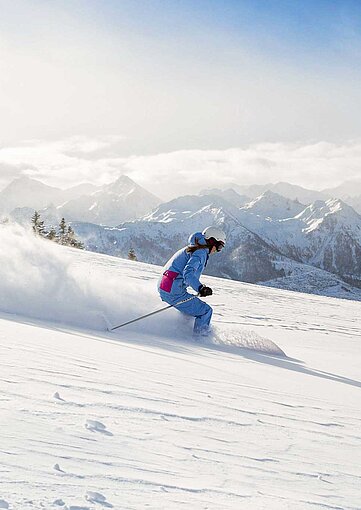Skifahrer auf den verschneiten Pisten der Kitzbüheler Alpen