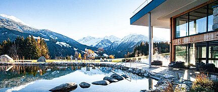 Sonnberghof Spa mit Schwimmbiotop vor alpiner Kulisse im Nationalpark Hohe Tauern