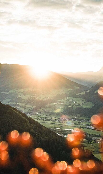 Sonnenaufgang über einem idyllischen Tal in den Bergen im Salzburger Land