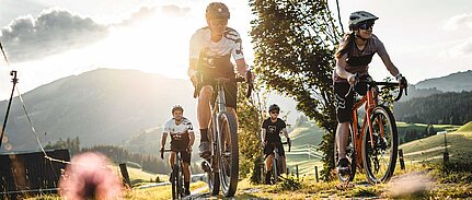 Gruppe von Mountainbikern genießt eine Fahrt bei Sonnenuntergang im Salzburger Land