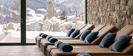 Entspannungsliegen im Wellnesshotel Sonnberghof Spa mit winterlichem Bergblick im Salzburger Land.