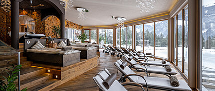 Komfortabler Spa-Bereich mit Liegen im Wellnesshotel Sonnberghof mit Bergblick im Winter.